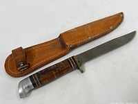 Vintage Boy Scouts of America camping knife with leather sheath, showing full knife and sheath together.