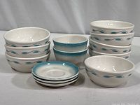 Full collection showing stacked bowls, fruit cups, and saucers featuring gray swirl and blue leaf decorative pattern