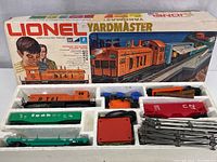 Photo of the complete electric train set with engine, four cars, transformer, track pieces, and accessories displayed in original packaging foam insert.