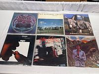 Top view of all six vinyl albums arranged in two rows of three, showing front covers with varied artwork illustrating artists L.T.D., Pat Metheny Group, Timbuk3, Stanley Turrentine, Flora Purim, Monty Alexander.