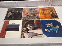 Six vinyl record albums laid out on a white surface showing covers of Weather Report, Brooklyn Dreams, Lee Ritenour, Transit, Simply Red, and Traffic albums in archival sleeves.