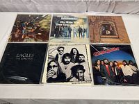 Six vinyl albums arranged in two rows of three on a white surface, showing all album covers clearly