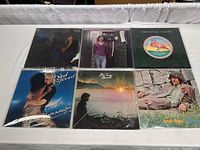 Six vintage vinyl record albums laid flat, showing covers from Boz Scaggs, Michael Franks, Christopher Cross, Rod Stewart, James Taylor.
