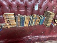 Overall display of 24 volumes arranged on leather bench.