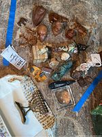 Overview of the carved wooden animal figures, menorah, pewter, and figurines spread on carpet with identification cards visible.