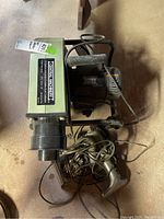 Photo showing side view of dust collector unit including handle and vacuum cleaner beneath it.