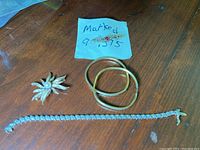 Overview of three bangles, tennis-style bracelet, spider brooch and handwritten note