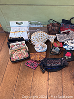 Overview of various handbags and clutches laid on wooden floor, showing different sizes, colors, and materials including tapestry and woven styles.