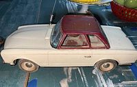 Side view of white and maroon vintage remote controlled Mercedes model car showing dirt, dust, and antenna