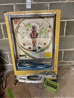 Front view of pachinko machine with lever, tray, bucket of balls
