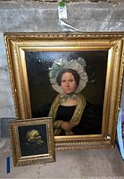 Both framed portraits displayed side by side on concrete floor