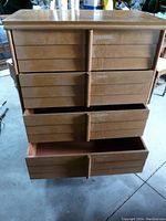 Front view of the dresser with drawers partially open, showing wear and wood grain.