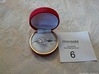 Sterling silver ring with three large princess cut crystals displayed in a red box.