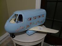 Blue Barbie vintage private plane with floral decals and Barbie logo, white folding wings, shown closed on a table.