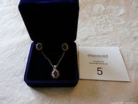 Necklace and earrings set in blue velvet box, overall view of lot