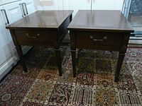Pair of Kroehler wooden side tables placed on a patterned rug, showing their rectangular tops and tapered legs.