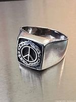 Close-up of the sterling silver peace symbol signet ring showing detailed design and condition.