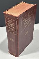 Red hard cover book titled 'The American Illustrated Medical Dictionary' by Dorland, 22nd edition, showing gilt lettering on spine and cover with some wear and fraying.