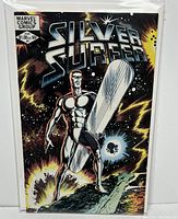 Silver Surfer #1 comic book cover front showing Silver Surfer holding silver board on cosmic background with explosion effects, bagged and boarded in protective sleeve