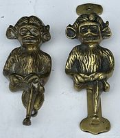 Photo of both brass door knockers side by side on white background showing front details