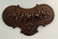 Full frontal view of the carved wooden cartouche mounted on wall