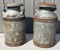 Front view of both milk cans side by side on gray backdrop