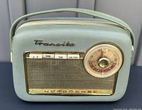 Front view of the green Nordmende Transita G radio showing speaker grille, waveband selector buttons, tuning dial, and brand logos