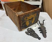 Wooden Holmes Cub box showing side and cast iron bug boot jack and Wilton eagle cast iron piece placed in front