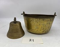 Antique brass bell and brass pot shown side by side on white background with lot number 21 card.