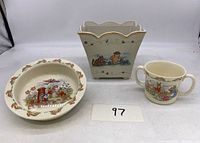 Front view of Bunnykins cup and bowl set with Lenox planter in background