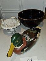 Photo showing vintage brown batter bowl, hand-painted decoy duck, and marble miniature bird bath with bird figurines, including damage observation