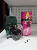 Christian Dior Poison Eau de Toilette bottle full with original box showing wear and unopened Prada Candy shower gel box with fashion illustration.