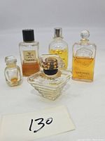 Front view of the five vintage perfume bottles shows Chanel No 5, Grès Cabochard, Caron Nocturnes, Lancome Tresor, and a small bottle.