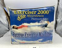 Front of the product box showing the Exerciser 2000 Elite MultiSpeed Passive Exercise Machine with title and branding.