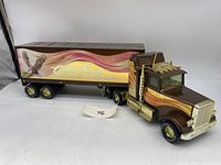 Full side view of the brown and gold toy Freightliner truck attached to the Golden Eagle Express trailer with eagle graphic showing the length and details.