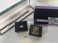 Overview of all jewelry items in boxes showing ring, watch, and bracelet