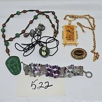 Full view of all jewelry items in the lot arranged on a white background, including necklaces, bracelet, earrings, and brooch.