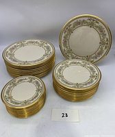 Full display of the three stacks of Lenox Castle Garden plates arranged by size, showing entire lot quantity.