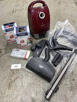 Overall view of vacuum, attachments, hoses and filter boxes arranged on floor