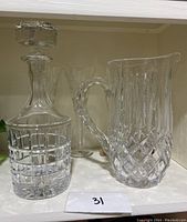 Waterford crystal decanter and water pitcher side by side, showing cut patterns and design details