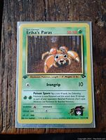 Front view of Erika's Paras 1st Edition Pokemon card showing full artwork, stats, and condition.
