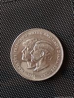 Obverse side of the coin showing Charles, Prince of Wales and Lady Diana Spencer profiles with inscription.