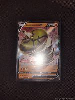 Photo of Sandaconda V holo foil full art Pokemon card showing card art, stats, and holo foil patterns.