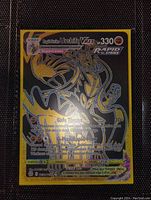 Front view of the Urshifu Black Gold VMAX holo full art card placed on a surface, showing holographic gold and black design.