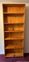 Front view of pine wood bookshelf showing all six shelves clearly with natural wood finish.