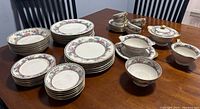 Overview of full set of Limoges Larkspur dishes on table including plates, bowls, cups, and serving pieces