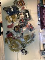 Photo of assorted navy and military badges, patches, and shoulder epaulets laid out on a table, many in sealed plastic bags and with price tags.