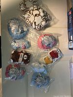 Photo showing various new badges featuring dragons, animated animals, and sports figures, all in sealed plastic bags.