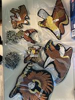 Full collection of eagle and Harley Davidson badges displayed in plastic packaging on white background