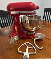 Full view of red mixer with bowl and attachments on table